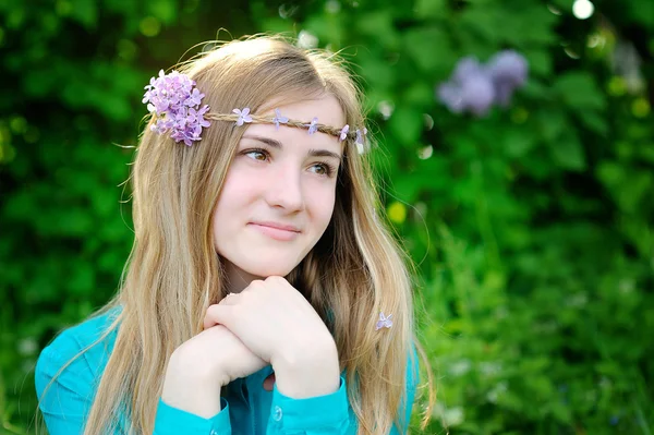 Schöne Frau mit fliederfarbenem Kranz spaziert durch den Park — Stockfoto