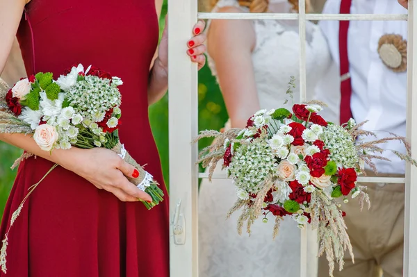 Bruid en bruidegom met een bruiloft boeket — Stockfoto