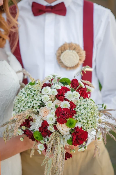 Bruid en bruidegom met een bruiloft boeket — Stockfoto