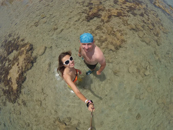 Älskande par i havet gör Selfy — Stockfoto