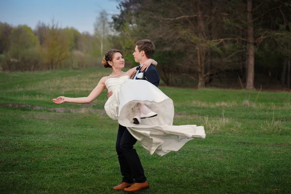 Felice sposa e lo sposo a piedi sul bordo di una pineta in primavera — Foto Stock