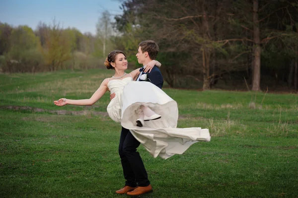 Novia feliz y novio caminando en el borde de un bosque de pinos en la primavera —  Fotos de Stock