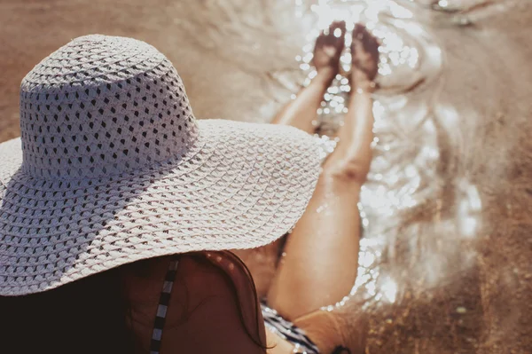 Mujer con sombrero cerca de la piscina en el complejo tropical — Foto de Stock