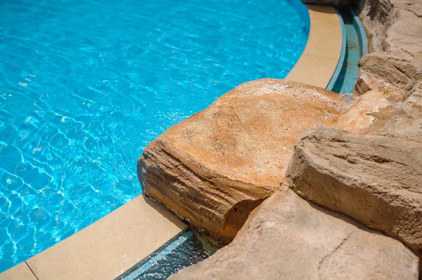 Canto de uma piscina com pedras decorativas — Fotografia de Stock
