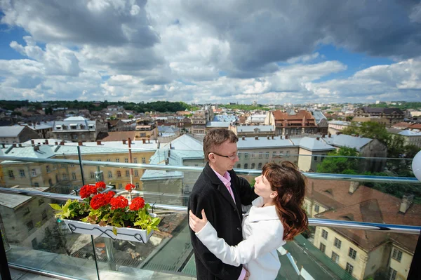Glückliches Paar, das sich auf dem Hintergrund der Stadt umarmt — Stockfoto