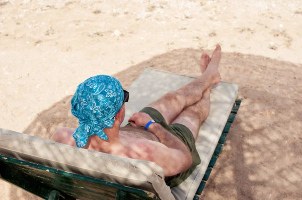 Schöner Mann am Strand, der auf seinem Liegestuhl schläft — Stockfoto