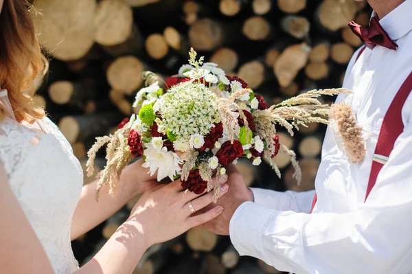 Menyasszony és a vőlegény gazdaság menyasszonyi csokor közelről — Stock Fotó