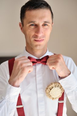 damat kırmızı kravat üzerinde beyaz bir gömlek giyer.