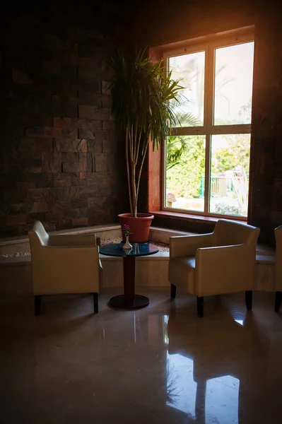 Zwei Stühle und ein Tisch in der Lobby am Fenster — Stockfoto