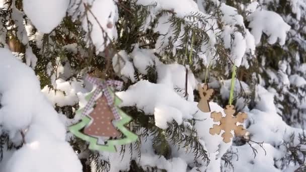 Décorations de Noël accrochées à un sapin de Noël enneigé 