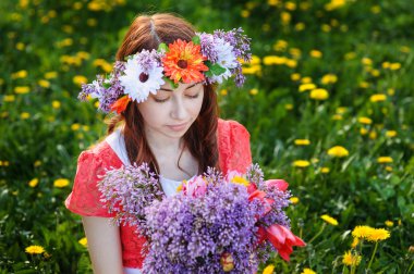 güzel kadın bir çelenk bir çayır üzerinde oturan