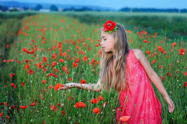 Счастливая девушка в красном платье на маковом поле — стоковое фото