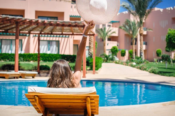 Frau liegt auf einer Liege am Pool des Hotels — Stockfoto