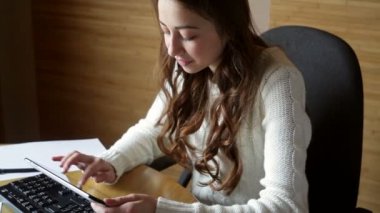 beyaz bir kazak güzel genç kadın bir bilgisayarda çalışıyor