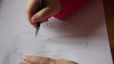 küçük bir kızın eli kağıda bir ağaç çizer