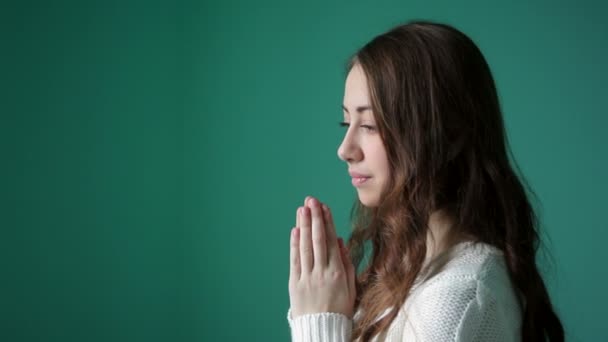 Mooie jonge vrouw gevouwen haar handen in gebed — Stockvideo