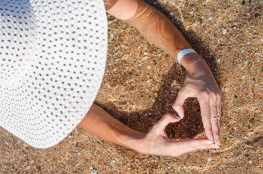 Woman in white hat lying in sea