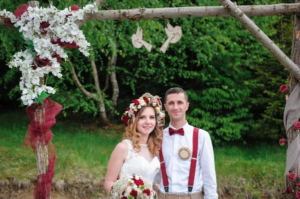 Bride and groom near wedding arch — Stok fotoğraf