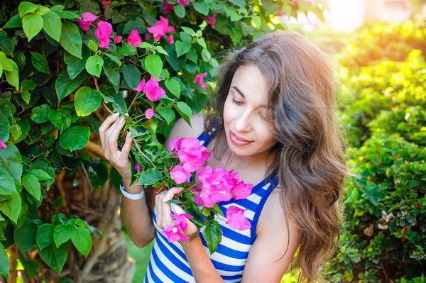 Beautiful woman smelling the flowers — Zdjęcie stockowe