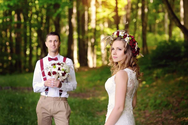 Braut und Bräutigam spazieren im Wald — Stockfoto