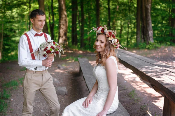 Bride and groom sitting in the summer park — Stock Photo, Image