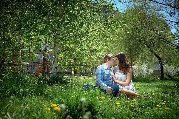 Çimenlerin üzerinde oturan kadın ve erkek — Stok fotoğraf