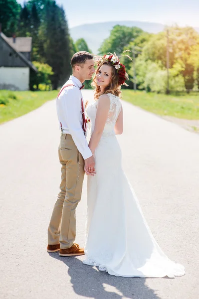 Bride and groom walking on the road — Stock Photo, Image