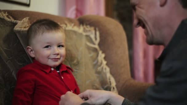 Père réfléchi aidant son garçon à mettre sa chemise — Video