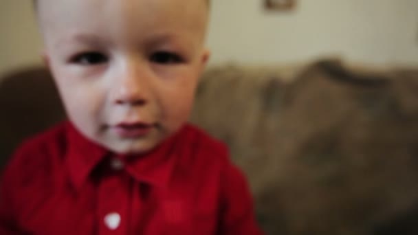 Glad liten pojke i en röd skjorta — Stockvideo