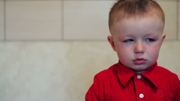 Sorglig liten pojke i en röd skjorta — Stockvideo