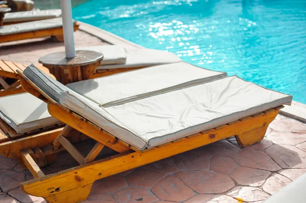 Drewniane łóżko przy basenie — Zdjęcie stockowe