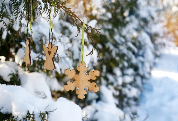Juguetes de madera en un árbol de Navidad cubierto de nieve — Foto de Stock