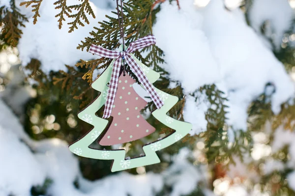 Juguetes de madera en un árbol de Navidad cubierto de nieve —  Fotos de Stock