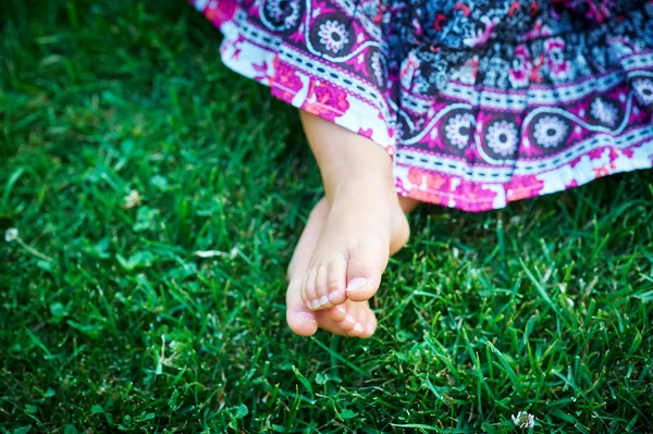 잔디 위에 앉아 있는 어린 소녀 — 스톡 사진