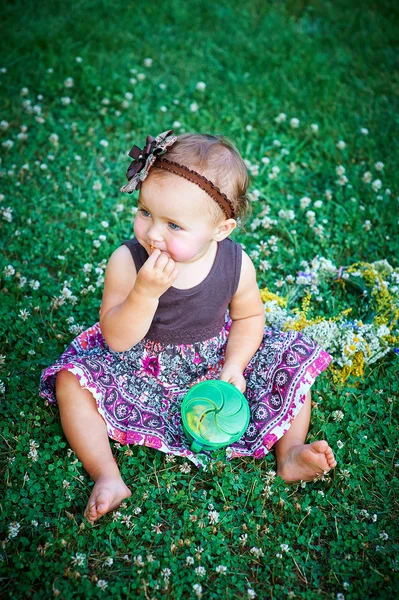 Petite fille assise sur l'herbe — Photo