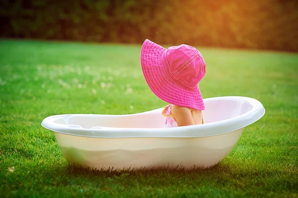 little girl in a red hat bathed in the bath