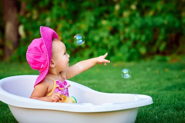 Bambina con un cappello rosso bagnata nel bagno — Foto Stock