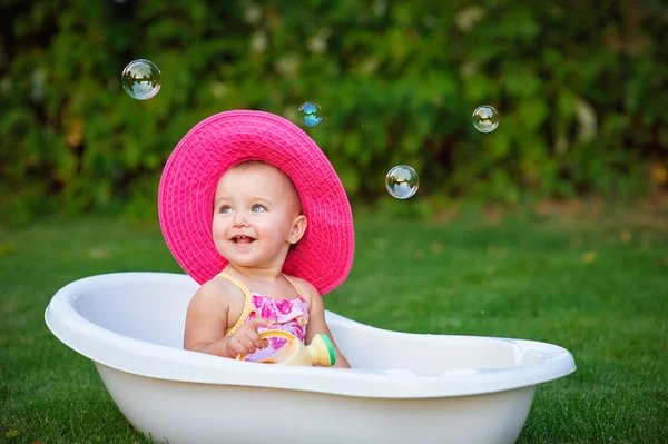 Petite fille dans un chapeau rouge baigné dans le bain — Photo