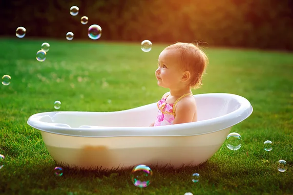 Bambina si bagna in un bagno con bolle di sapone — Foto Stock