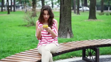 Parkta bir bankta oturan güzel kadın