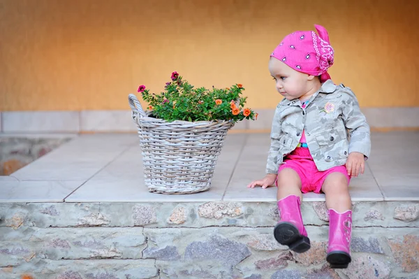 Kleines Mädchen in rosa Stiefeln sitzt auf den Stufen — Stockfoto