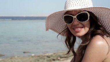 şapka ve güneş gözlüğü kumsalda güneşlenme güzel kadın