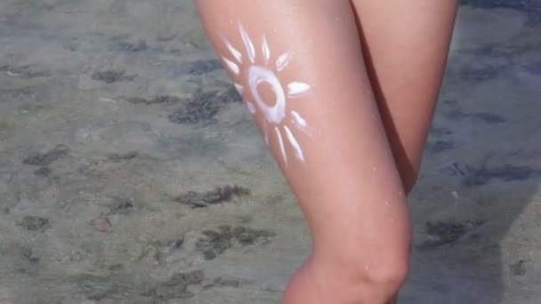 Close up sun painted by sun cream on woman's leg — Stock Video