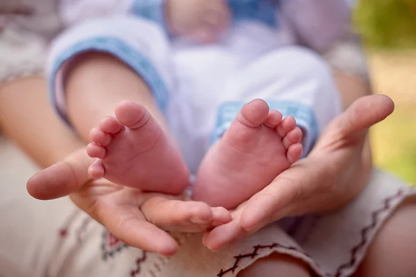 Father hold the feet of his new born son — стоковое фото