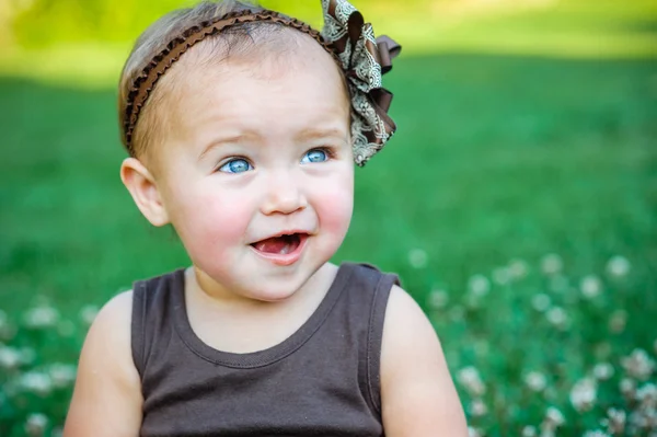 かわいい女の子が草の上に座って — ストック写真