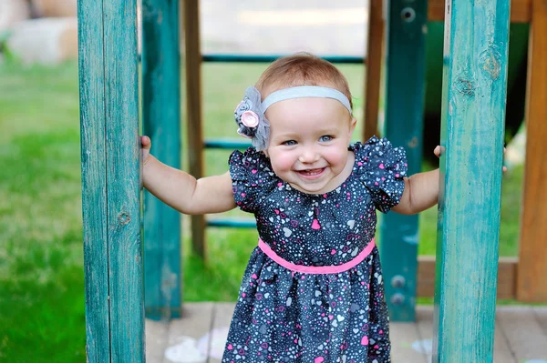 Glückliches kleines Mädchen klettert auf Spielplatz im Freien — Stockfoto