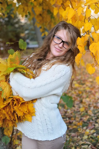 Young pretty woman in park makes a wreath of leaves — Stock Photo, Image