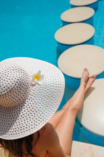 Bella giovane donna seduta sul bordo della piscina — Foto Stock