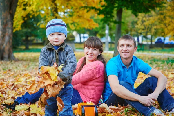 Familia joven caminando en el parque de otoño — Foto de Stock