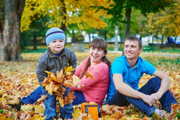 Familia joven caminando en el parque de otoño — Foto de Stock